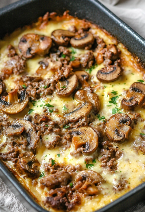 Hamburger mushroom bake with melted cheese in a casserole dish