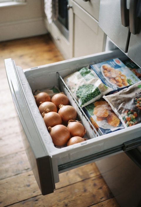 Onions sitting in an open freezer drawer