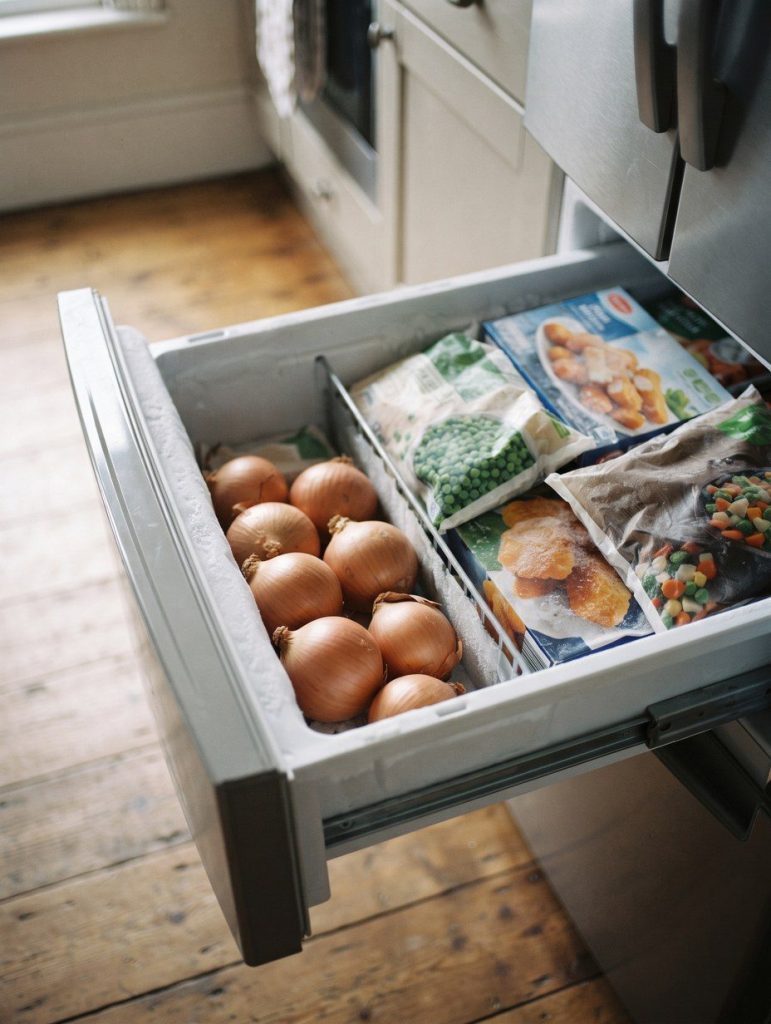 Onions sitting in an open freezer drawer