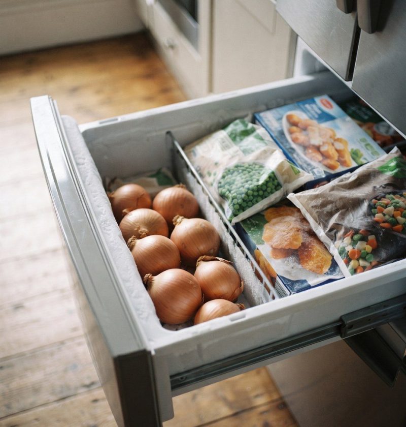 Onions sitting in an open freezer drawer