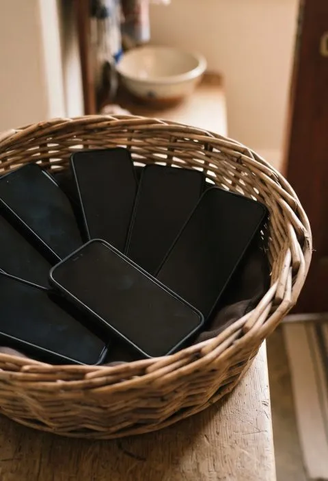 Basket of phones by the door during Sunday supper